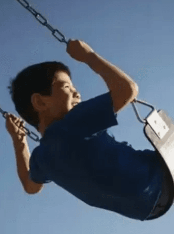 child playing on a swing